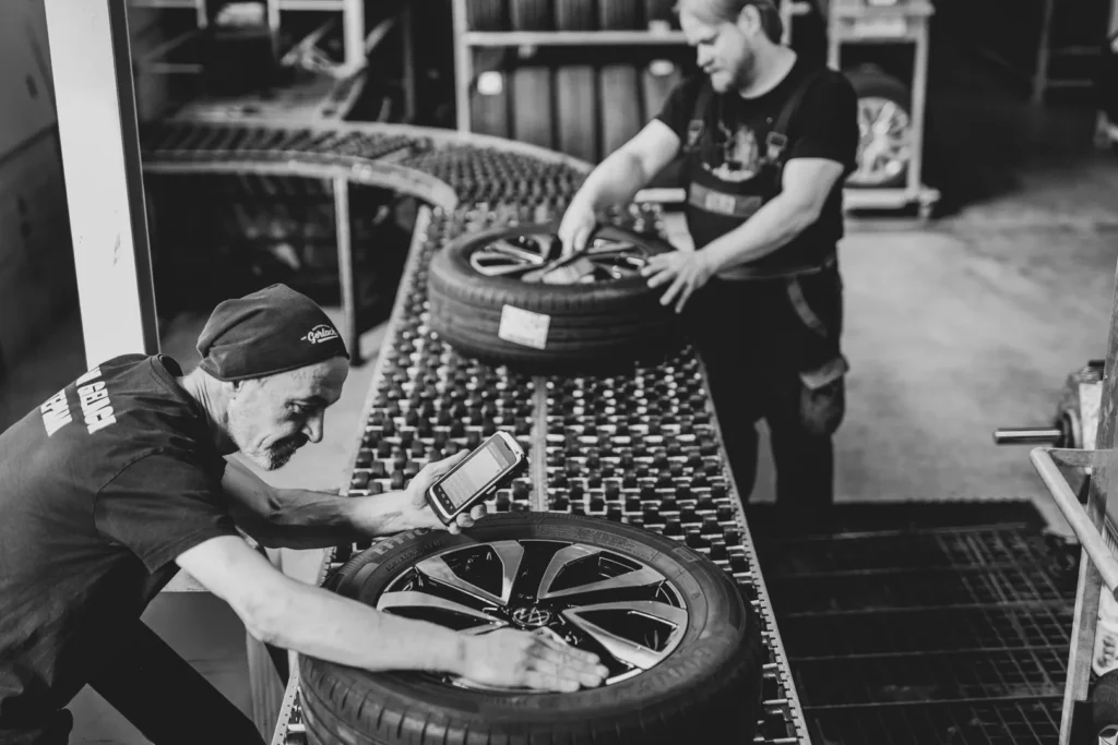 Mitarbeiter bei Räderlogistik beim Reifen einlagern und Prüfen im Lager